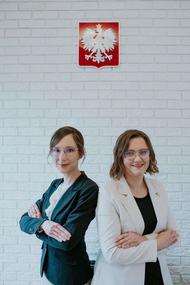 Adwokat Judyta Ciesielska i adwokat Katarzyna Markiewicz na tle godła Polski